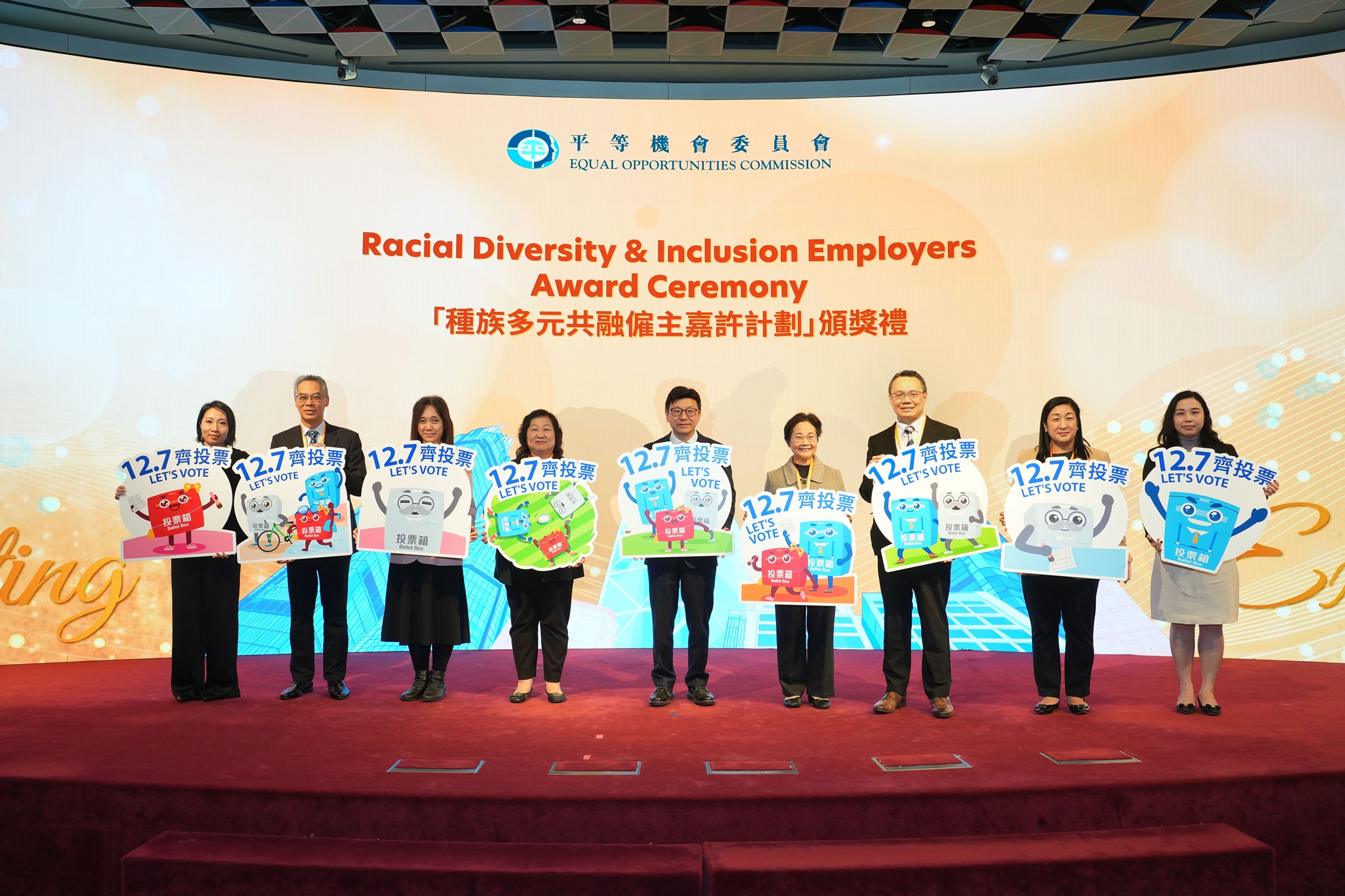 香港特别行政区政府劳工及福利局局长孙玉菡先生（中）、平机会主席林美秀女士（右四）、平机会委员陈丽群女士（左四）、王伟伦博士（右三）、涂淑怡女士（左三）、Aruna Gurung女士（右二），以及平机会行政总监（营运）朱崇文博士（左二）、主管（政策、研究及培训）徐妤婷女士（右一）和主管（机构传讯）赖月玲女士（左一）主持「种族多元共融雇主嘉许计划」颁奖礼的开幕仪式，并呼吁市民于立法会换届选举投票，携手构建种族共融社会。